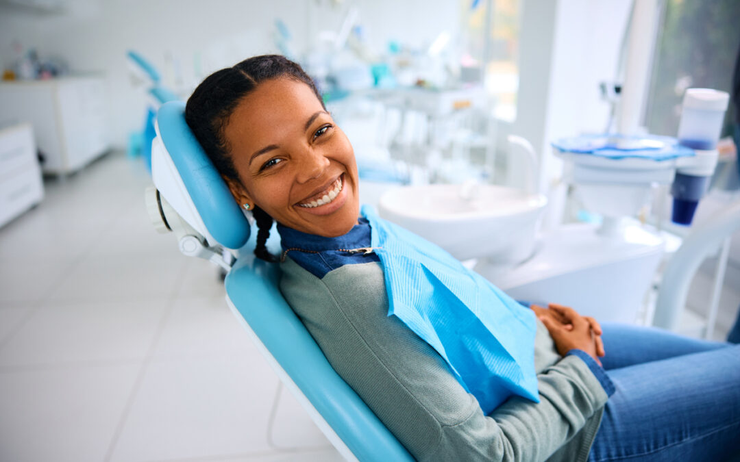 African American woman smiling in dentist's chair as the featured image for "How Often Should You Have Professional Dental Cleaning?"